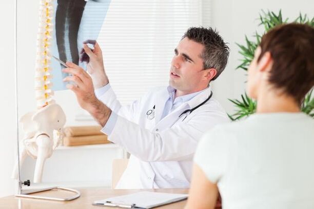 liječnik pokazuje oštećenje kralježnice zbog cervikalne osteohondroze